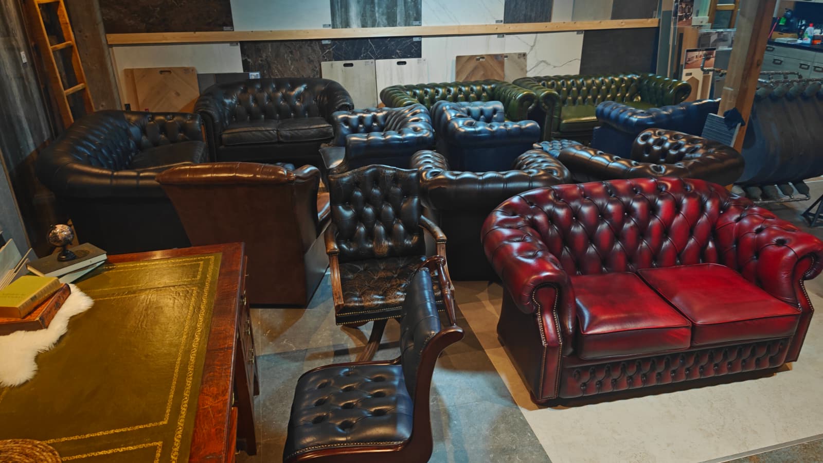 Showroom overzicht met Chesterfields en boekenkast